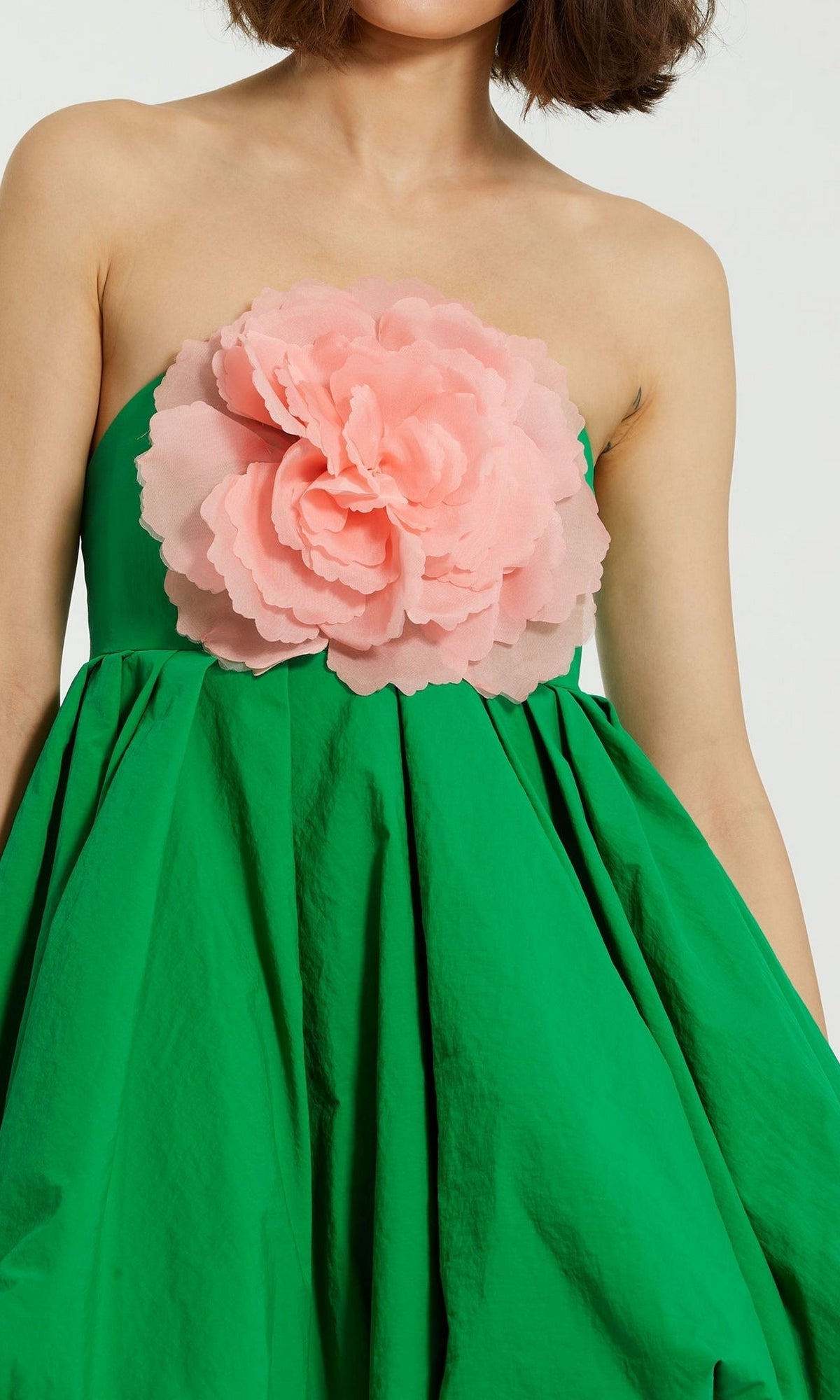 Wearing the Mac Duggal 20931 Short Bubble Party Dress in green with a strapless cut and a bold, layered pink flower accent makes for a standout look at any semi-formal party.